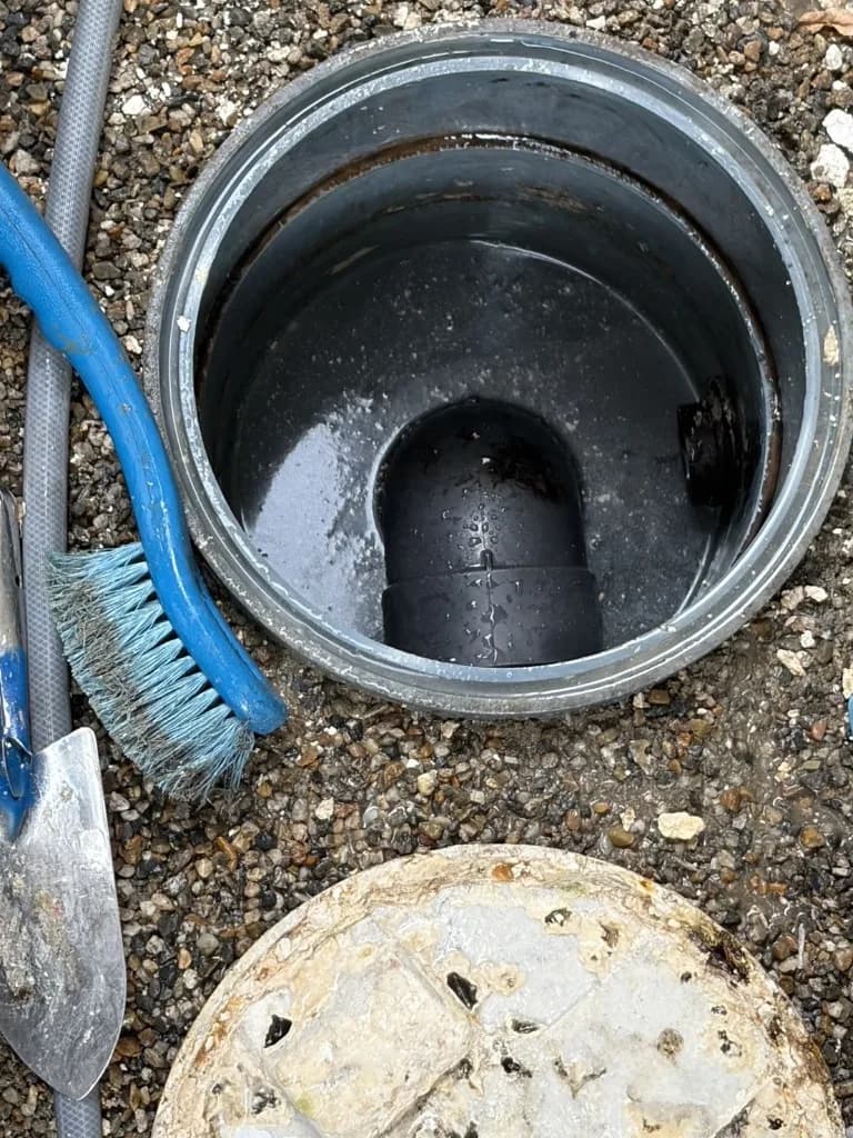 排水桝を高圧洗浄で清掃している作業の様子